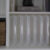 Scrapbook storage display cases stacked upright on a bookshelf