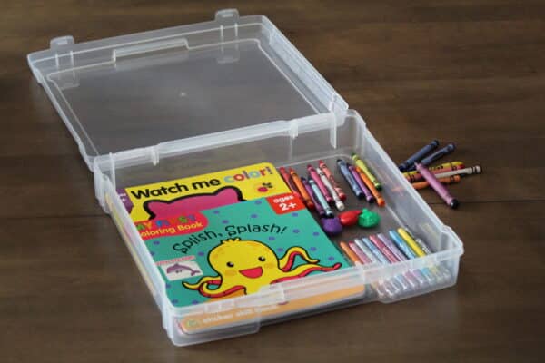 scrapbook storage display case with kids books and coloring crayons inside