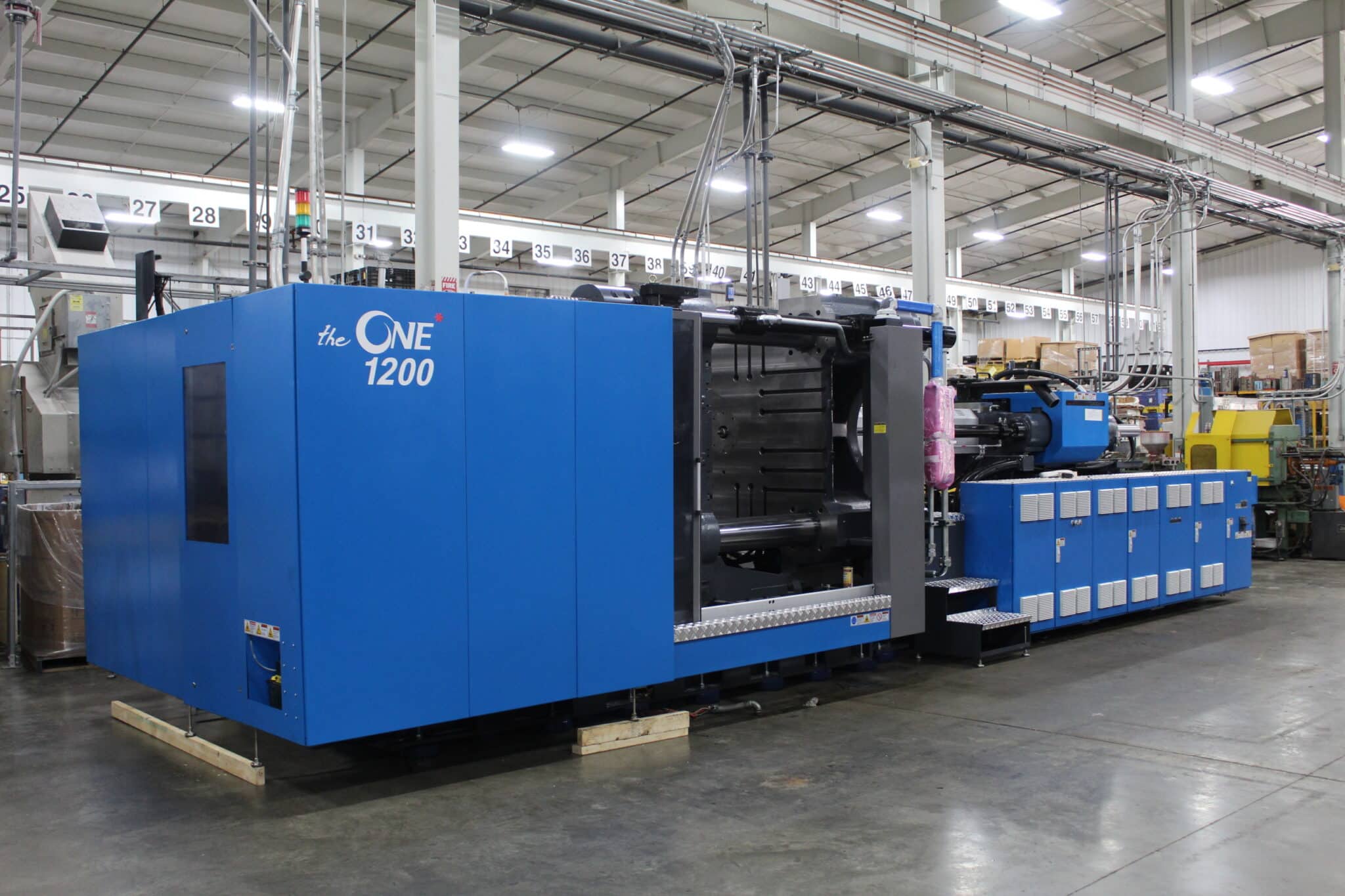 Custom injection molding press on the production floor at Pioneer Plastics