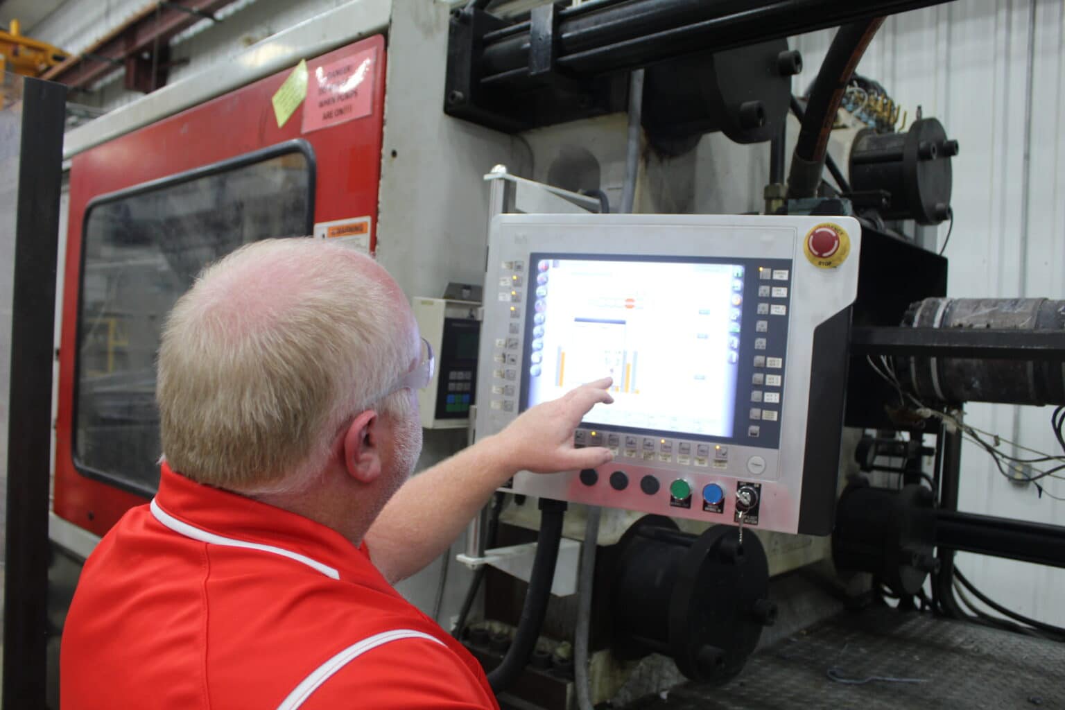 Pioneer worker working on a custom injection project at the molding machine