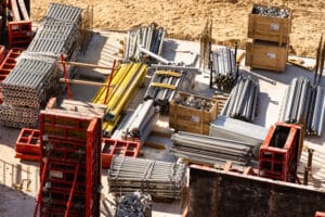 Construction materials and equipment organized at a residential complex construction site.