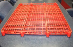 Red plastic rack on a table, ideal for storage and organization solutions.