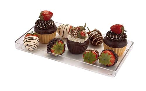 Delicious chocolate cupcakes and strawberries on a clear tray, perfect for dessert lovers.