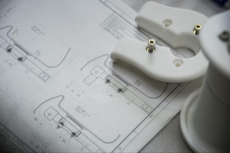 White mechanical parts design schematic detailing components and assembly.