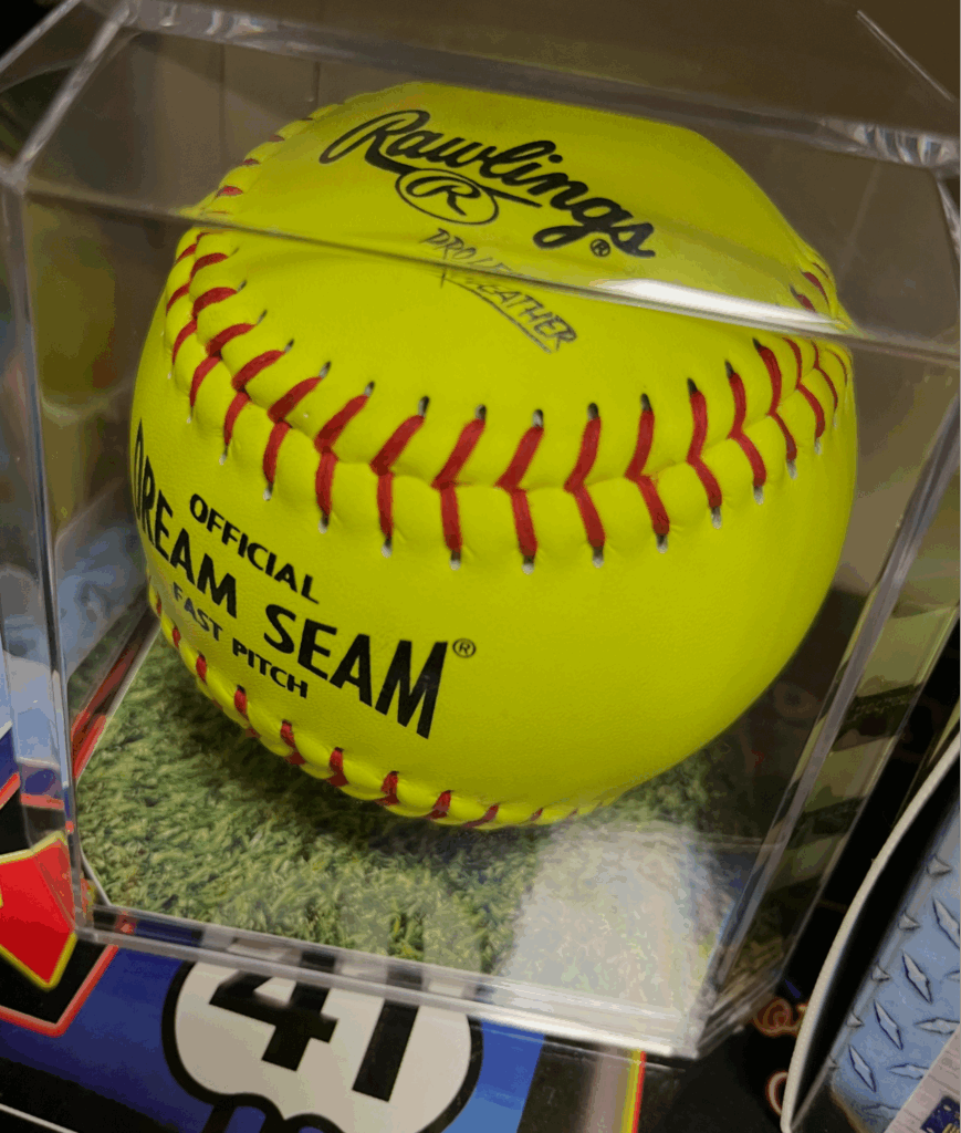 Autographed softball displayed in a clear protective case. Perfect for collectors.