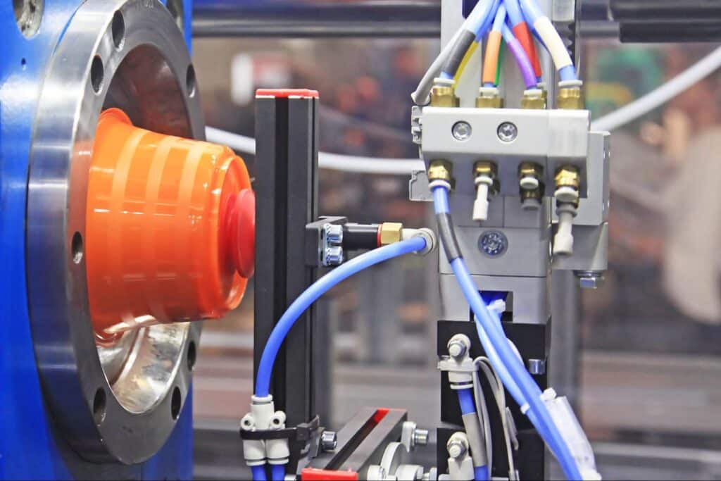 Industrial machinery showcasing fluid control systems and bright orange components in operation.