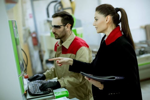 Workers collaborating in a factory setting, optimizing machinery and processes.